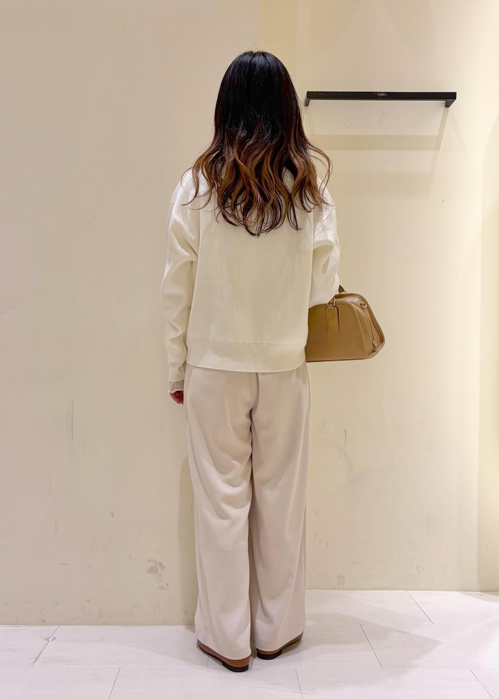 ホワイト系のTシャツ/カットソー、イエロー系のローファー、ベージュ系のボストンバッグを着用したレディースの冬コーディネートの4枚目の写真