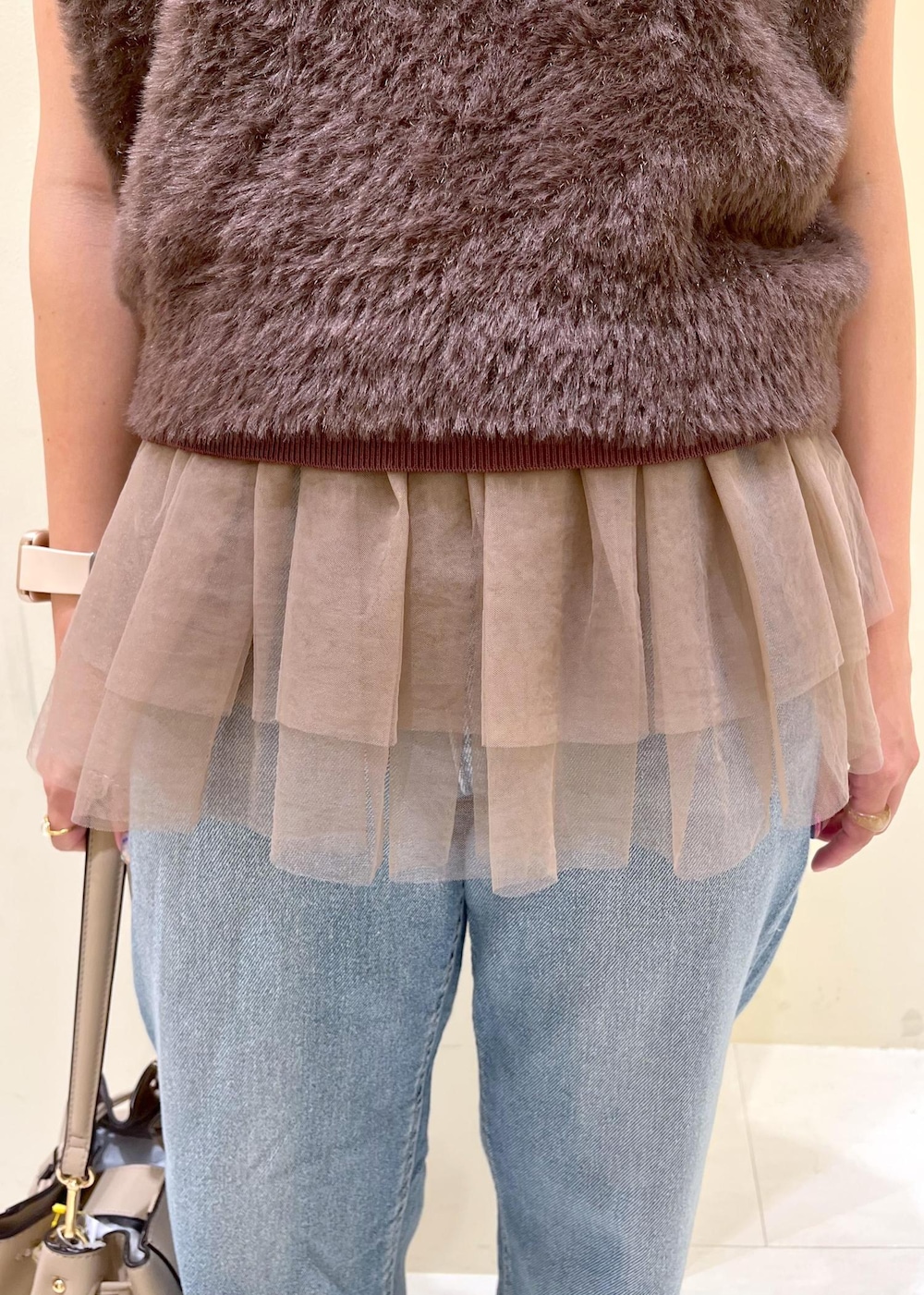 グレー系のローファー、ブルー系のデニムパンツ、ベージュ系のショルダーバッグを着用したレディースの夏コーディネートの6枚目の写真