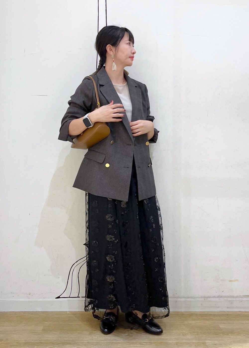 ブラック系のスカート、ベージュ系のTシャツ/カットソー、ブラウン系のテーラードジャケットを着用したレディースの秋コーディネートの3枚目の写真