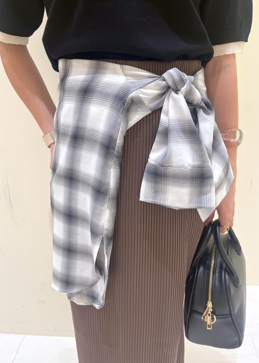 ブラック系のスカート、ブラック系のボストンバッグ、ブラック系のポロシャツを着用したレディースの夏コーディネートの6枚目の写真