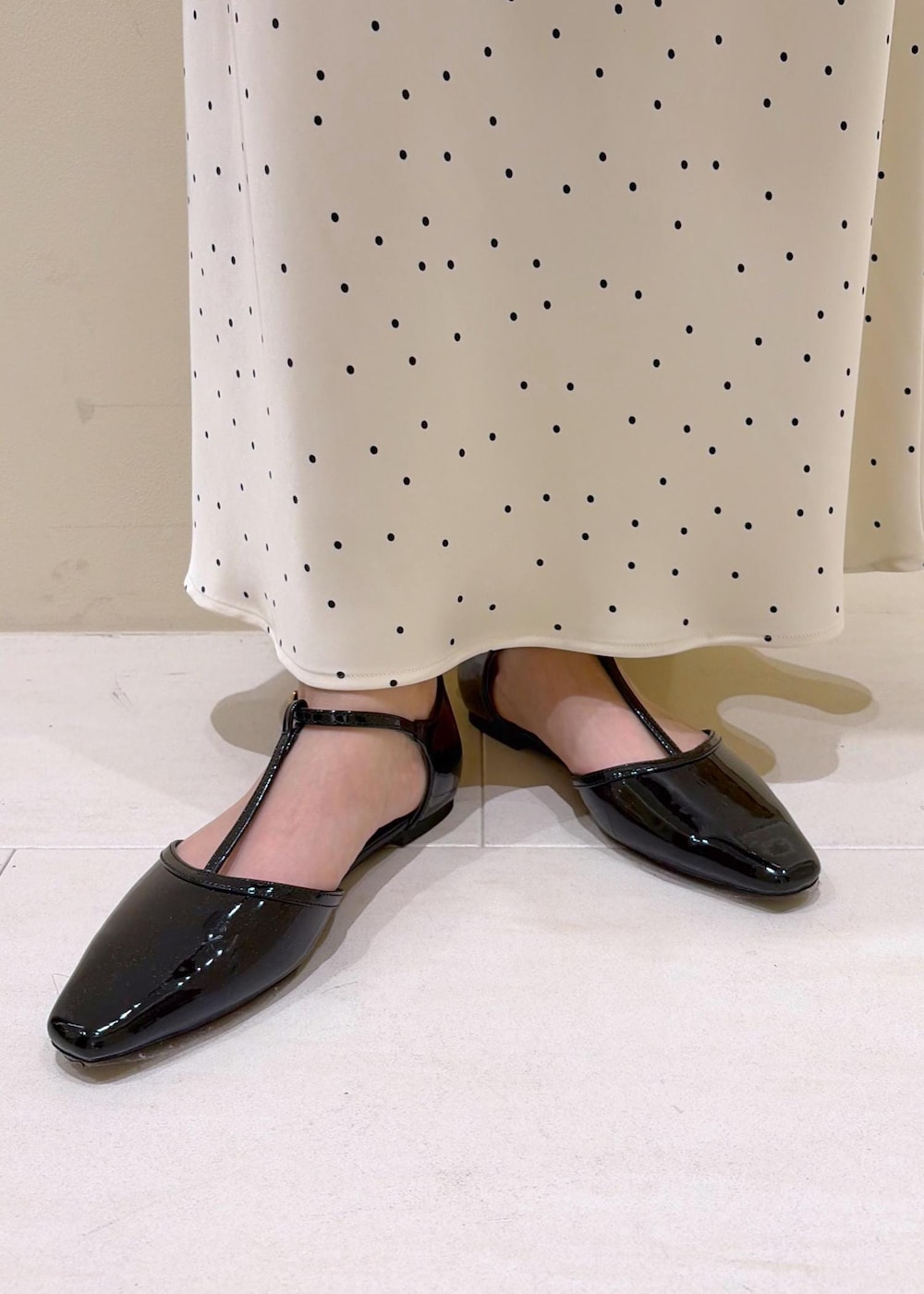 ブラック系のパンプス、ブラウン系のショルダーバッグ、ホワイト系のスカートを着用したレディースの春コーディネートの10枚目の写真