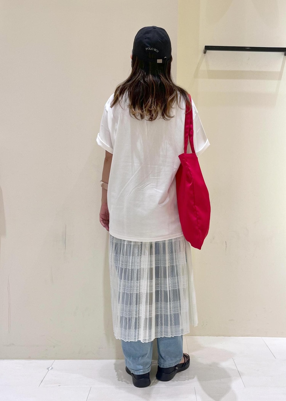 ブルー系のデニムパンツ、ホワイト系のスカート、ブラック系のサンダルを着用したレディースの夏コーディネートの4枚目の写真