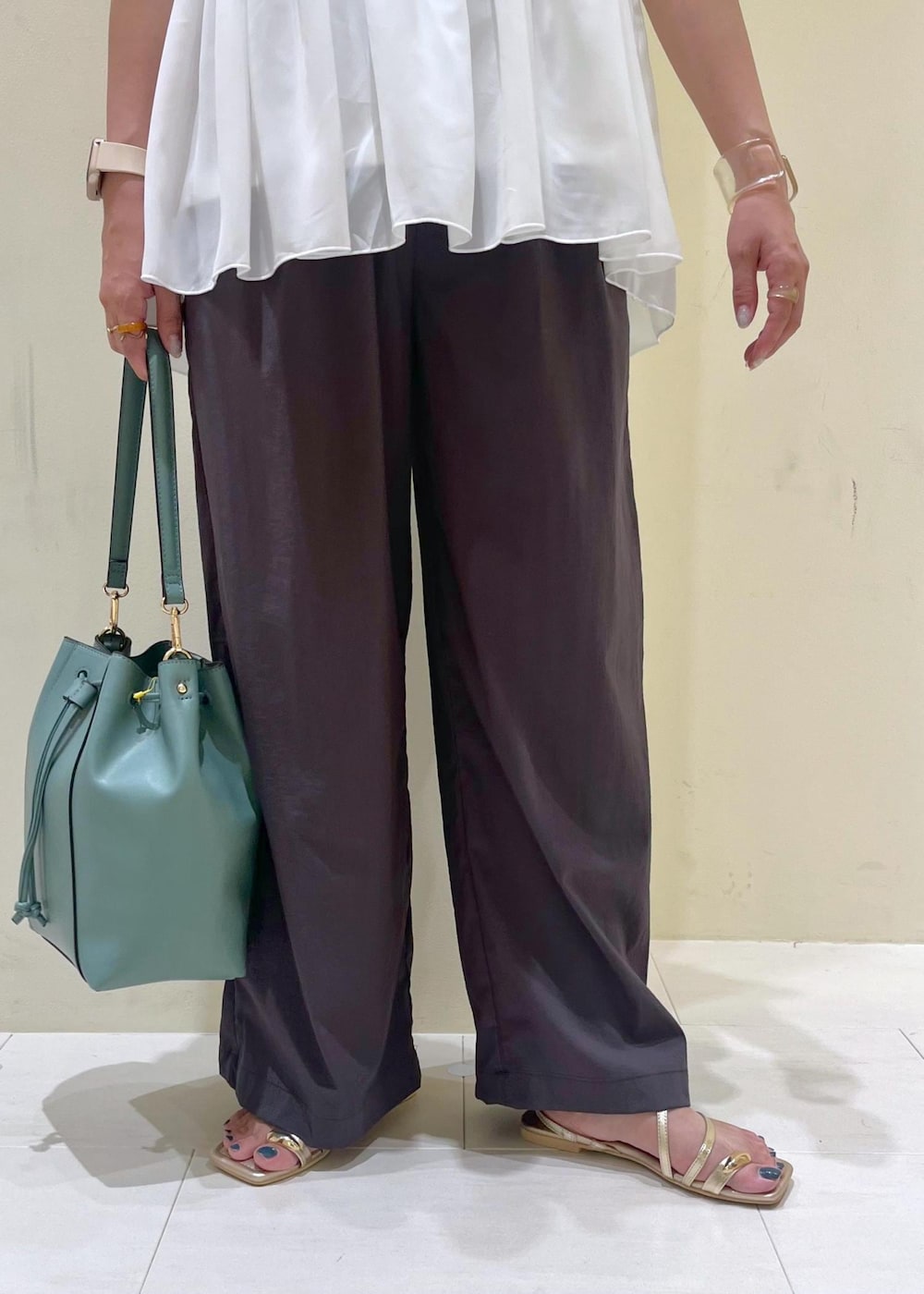 ブルー系のショルダーバッグ、グレー系のその他パンツ、ゴールド系のサンダルを着用したレディースの夏コーディネートの8枚目の写真