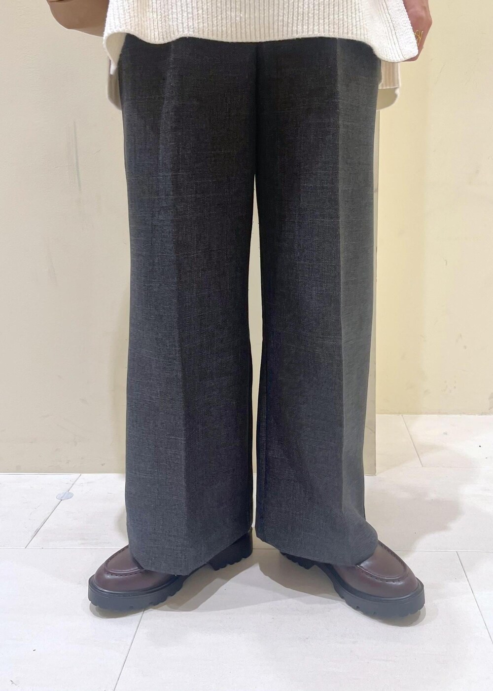 ホワイト系のニット/セーター、グレー系のスラックス、ブラウン系のローファーを着用したレディースの冬コーディネートの9枚目の写真