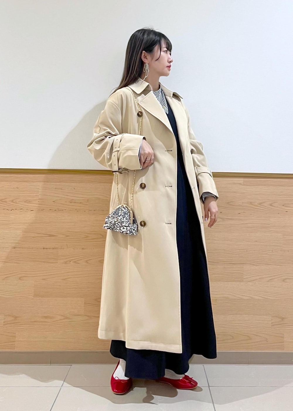 グレー系のショルダーバッグ、ブルー系のシャツ/ブラウス、ベージュ系のトレンチコートを着用したレディースの春コーディネートの10枚目の写真