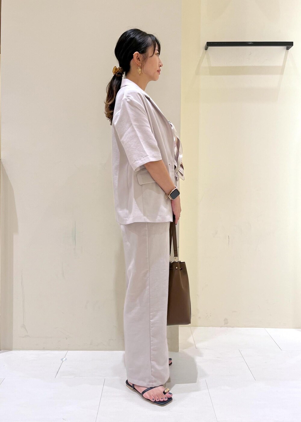 ベージュ系のテーラードジャケット、その他のニット/セーター、ブラウン系のショルダーバッグを着用したレディースの秋コーディネートの3枚目の写真