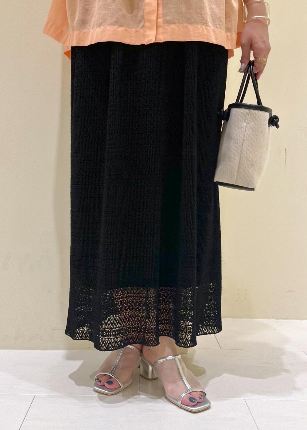 オレンジ系のシャツ/ブラウス、シルバー系のパンプス、ブラック系のトートバッグを着用したレディースの夏コーディネートの8枚目の写真