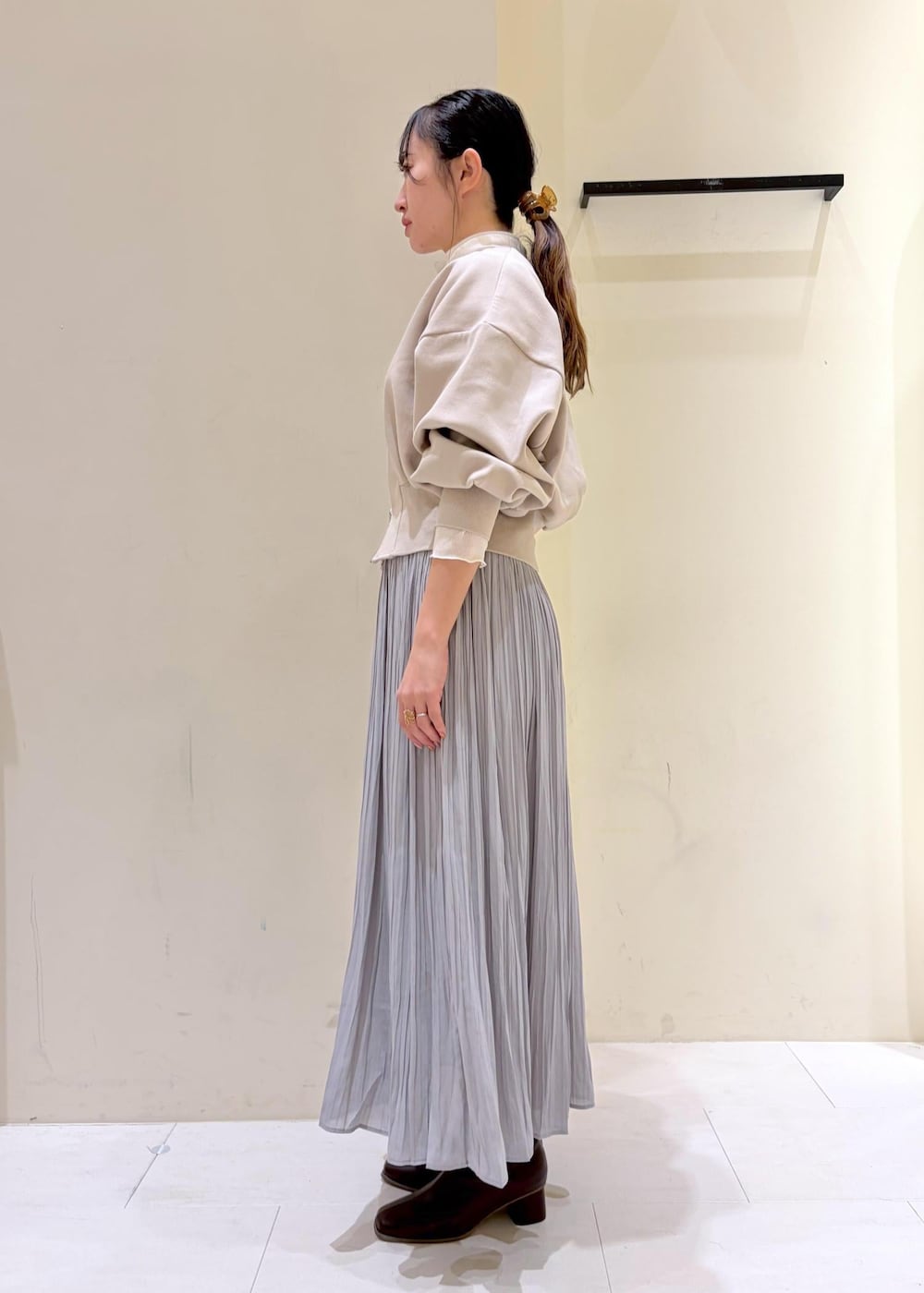 グレー系のスカート、ベージュ系のカーディガン/ボレロ、ホワイト系のトートバッグを着用したレディースの冬コーディネートの4枚目の写真