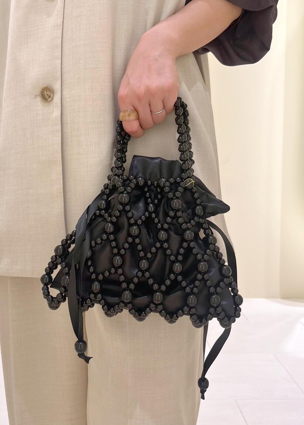 イエロー系のローファー、ブラック系のハンドバッグ、ベージュ系のベストを着用したレディースの春コーディネートの10枚目の写真