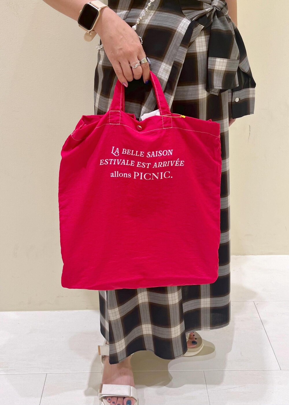 ブラック系のニット/セーター、ホワイト系のサンダル、レッド系のトートバッグを着用したレディースの夏コーディネートの9枚目の写真