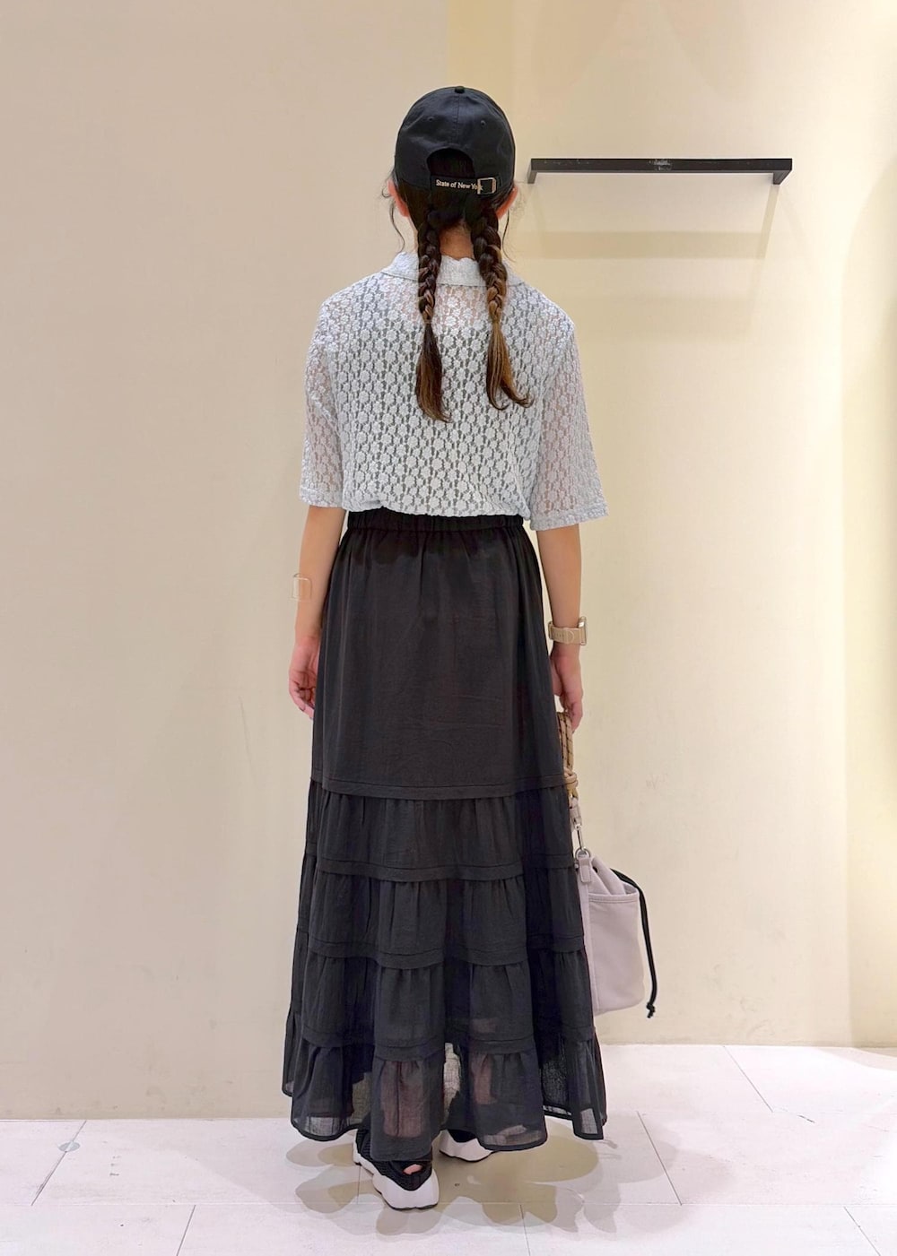 グレー系のショルダーバッグ、ブラック系のスカート、ブルー系のシャツ/ブラウスを着用したレディースの夏コーディネートの3枚目の写真