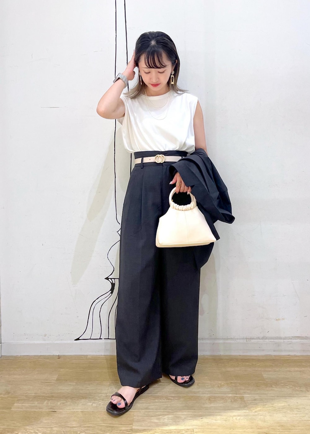 ブラック系のサンダル、グレー系のその他パンツ、ホワイト系のTシャツ/カットソーを着用したレディースの夏コーディネートの3枚目の写真