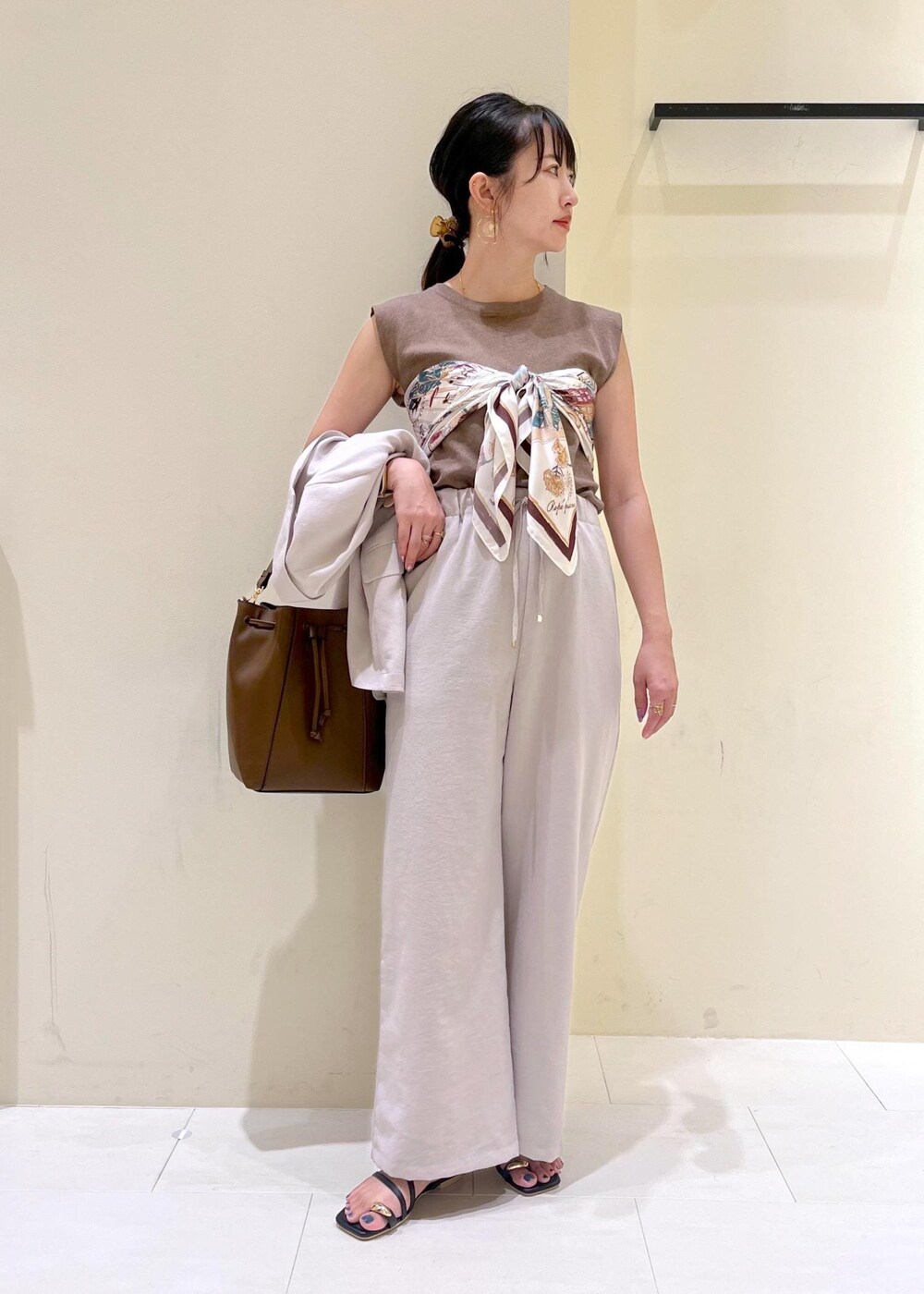 ベージュ系のテーラードジャケット、その他のニット/セーター、ブラウン系のショルダーバッグを着用したレディースの秋コーディネートの10枚目の写真