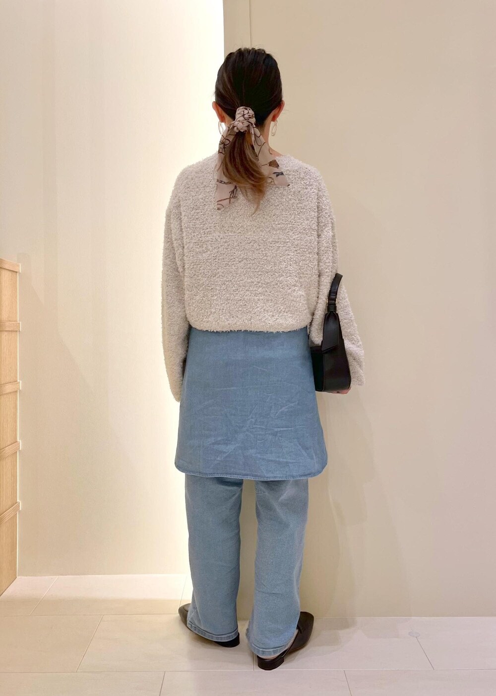 ブルー系のデニムパンツ、ブルー系のシャツ/ブラウス、グレー系のニット/セーターを着用したレディースの春コーディネートの4枚目の写真