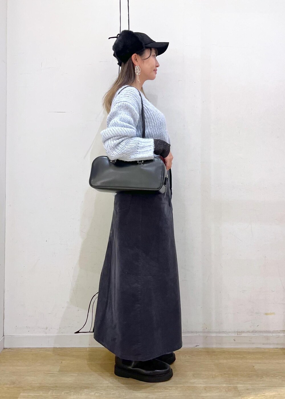 ブラック系のニット/セーター、ブラック系のブーツ、ブラック系のボストンバッグを着用したレディースの冬コーディネートの4枚目の写真