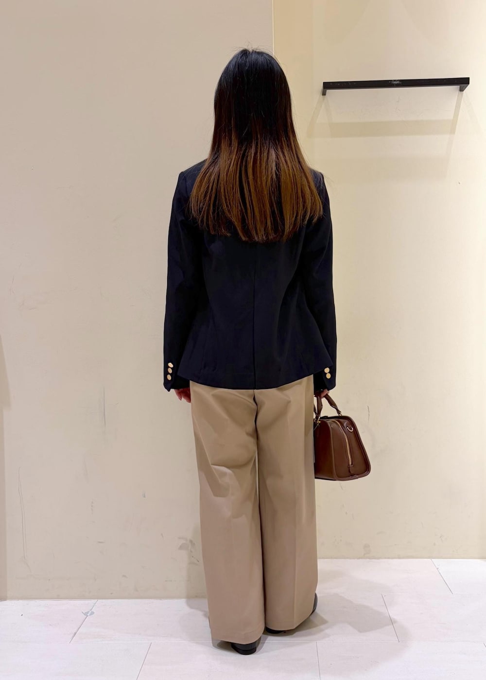 ブラック系のローファー、ブラウン系のボストンバッグ、ブルー系のテーラードジャケットを着用したレディースの冬コーディネートの3枚目の写真