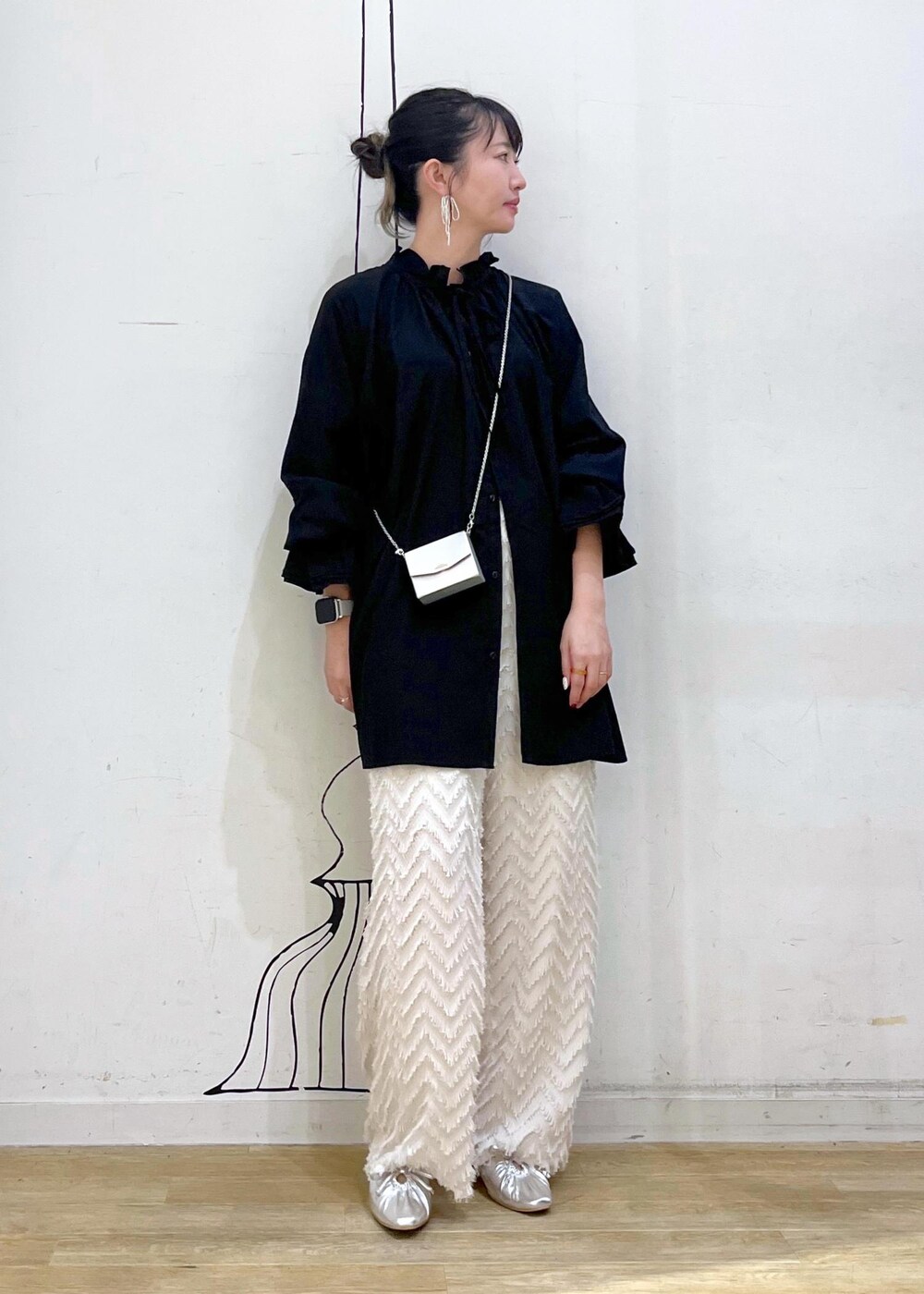 シルバー系のパンプス、ブラック系のシャツ/ブラウス、シルバー系のショルダーバッグを着用したレディースの秋コーディネートの2枚目の写真