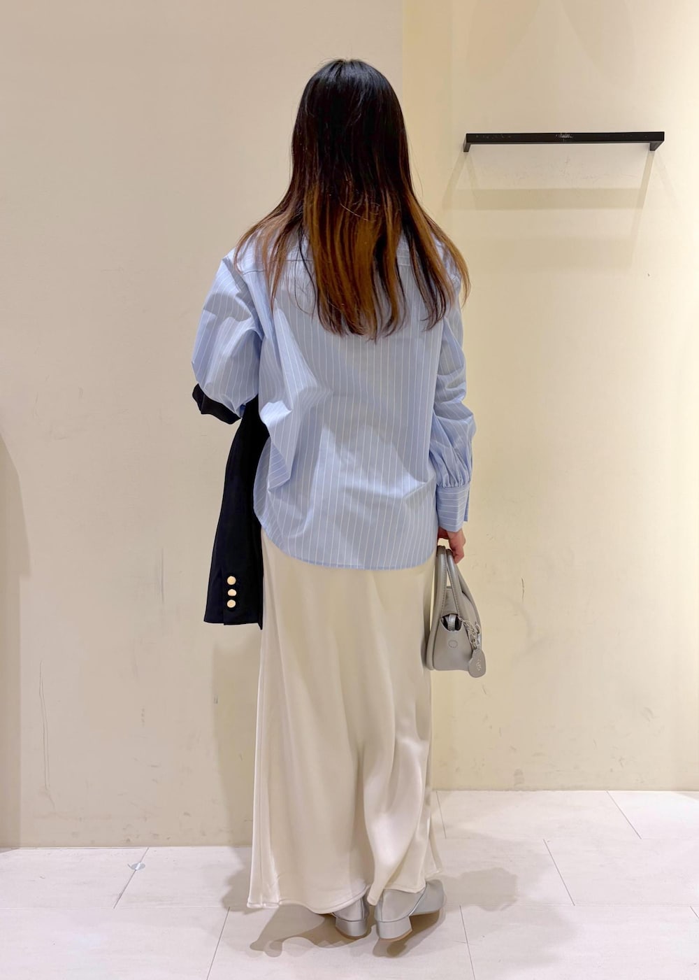 シルバー系のショルダーバッグ、ブルー系のテーラードジャケット、ブルー系のシャツ/ブラウスを着用したレディースの春コーディネートの3枚目の写真