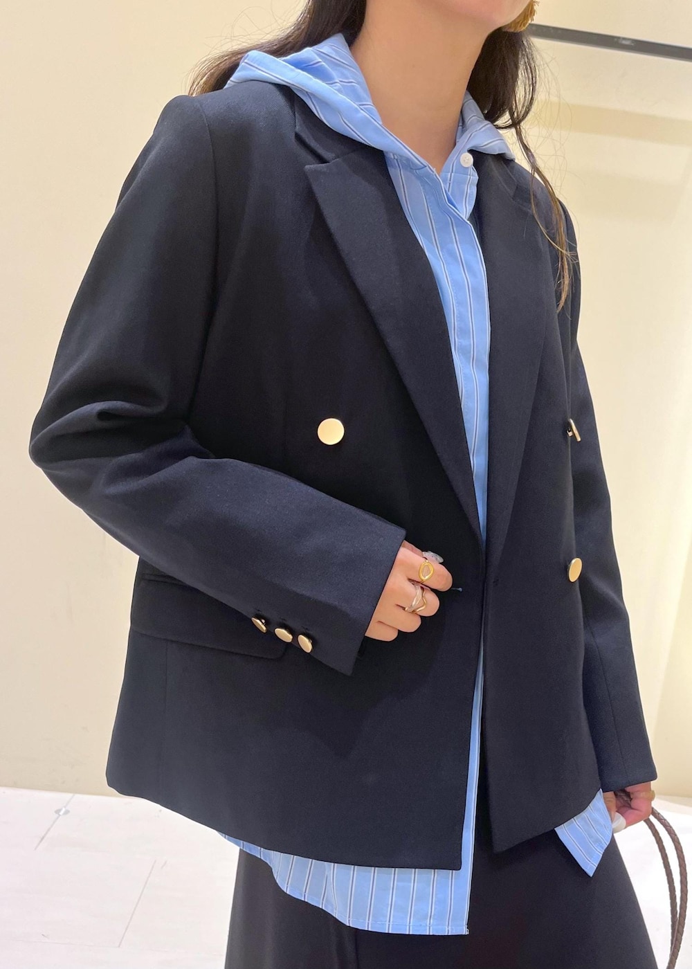 ブラウン系のトートバッグ、ブラウン系のトートバッグ、ブルー系のテーラードジャケットを着用したレディースの秋コーディネートの6枚目の写真