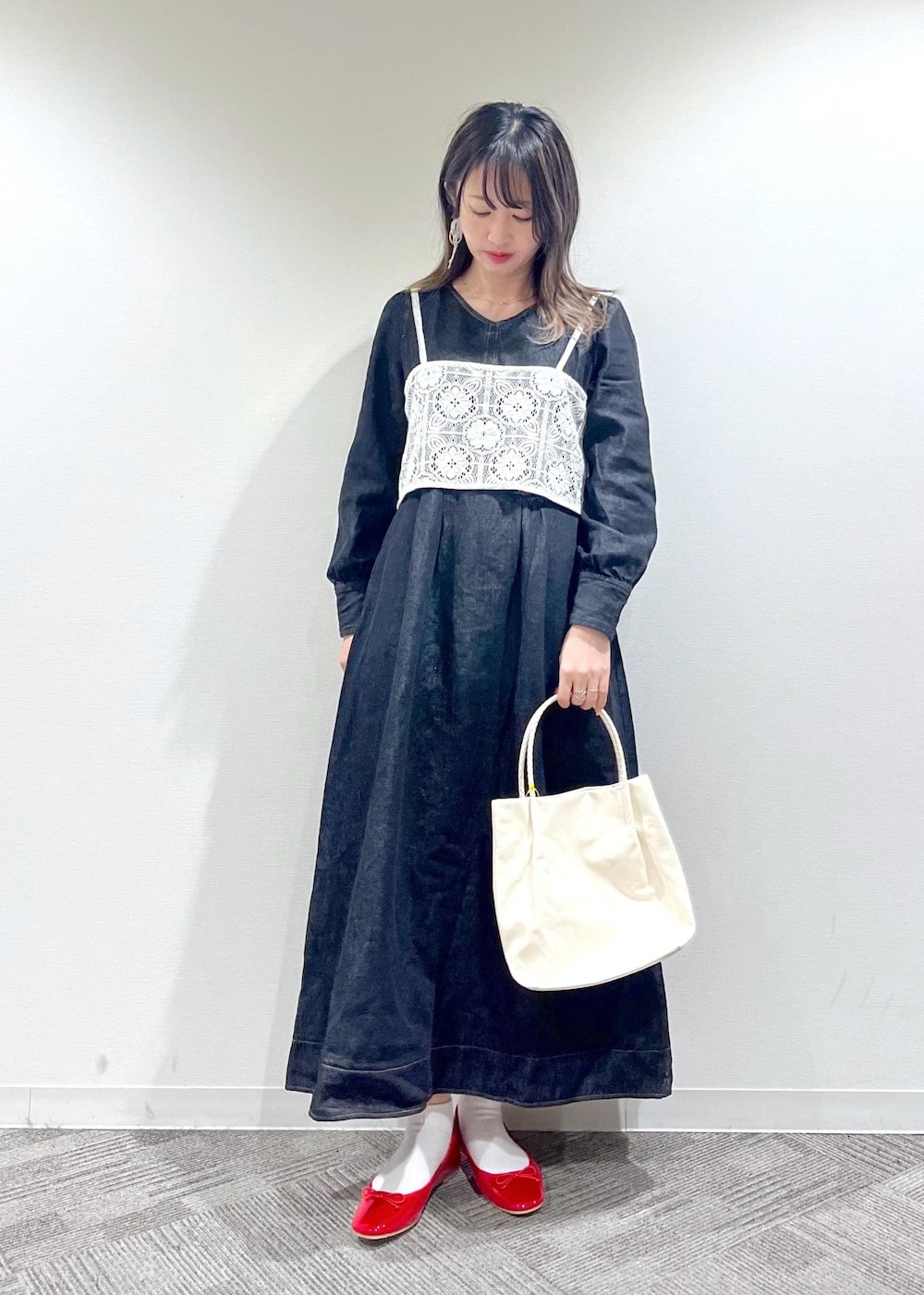 ホワイト系のトートバッグ、ホワイト系のキャミソール、レッド系のバレエシューズを着用したレディースの冬コーディネートの2枚目の写真