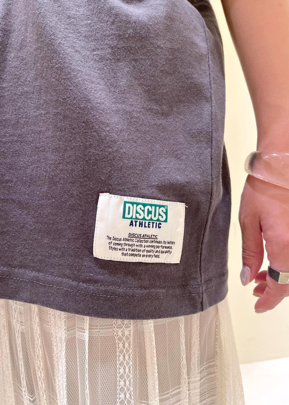 イエロー系のトートバッグ、ホワイト系のスカート、ベージュ系のその他パンツを着用したレディースの夏コーディネートの7枚目の写真