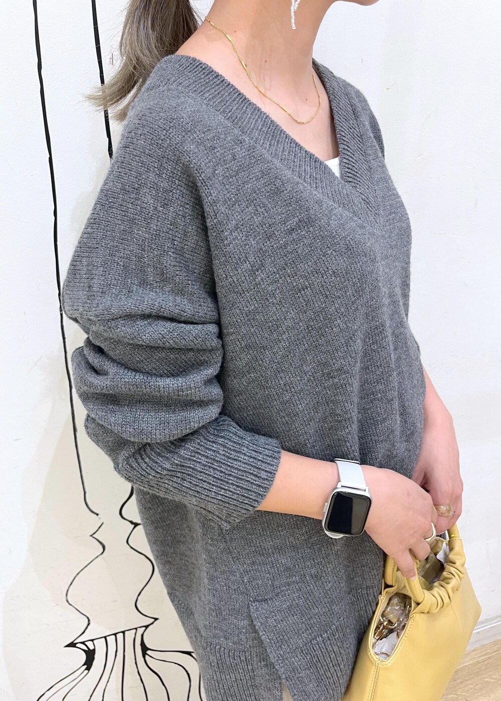 グレー系のタンクトップ、ブラック系のパンプス、イエロー系のショルダーバッグを着用したレディースの夏コーディネートの4枚目の写真