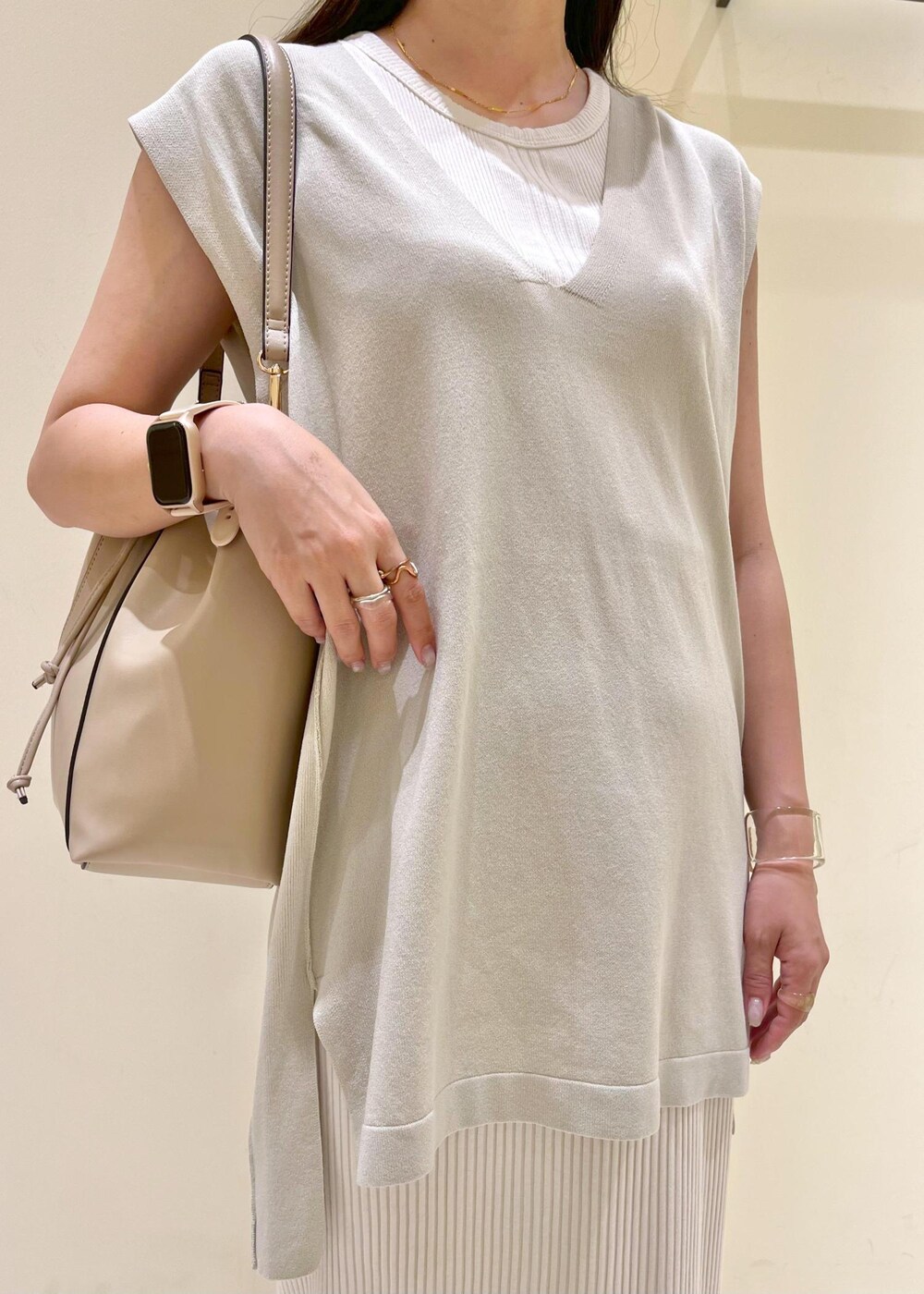 ベージュ系のタンクトップ、シルバー系のサンダル、ベージュ系のショルダーバッグを着用したレディースの夏コーディネートの6枚目の写真