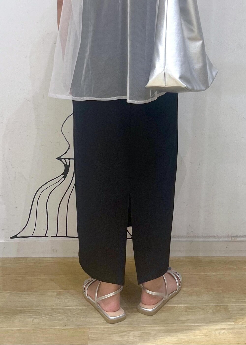 シルバー系のサンダル、ブラック系のスカート、シルバー系のトートバッグを着用したレディースの夏コーディネートの6枚目の写真