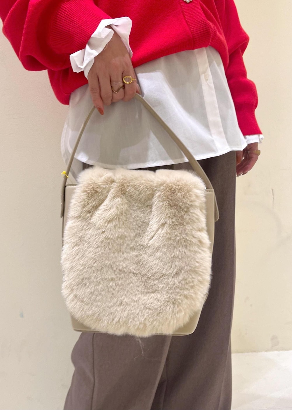 ベージュ系のスラックス、ホワイト系のシャツ/ブラウス、ブラック系のブーツを着用したレディースの冬コーディネートの9枚目の写真