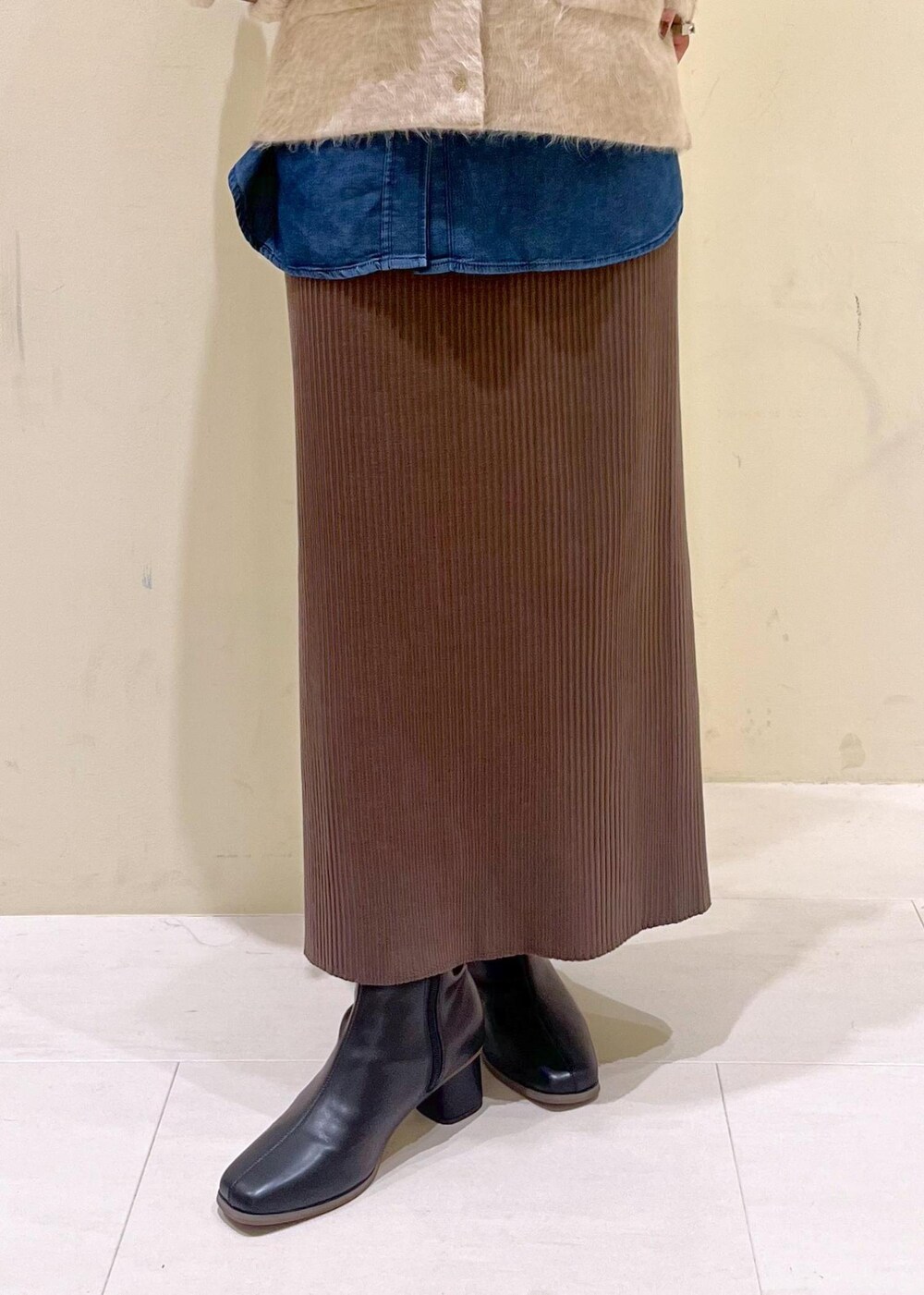 ブルー系のシャツ/ブラウス、ベージュ系のカーディガン/ボレロ、ブラック系のブーツを着用したレディースの秋コーディネートの7枚目の写真