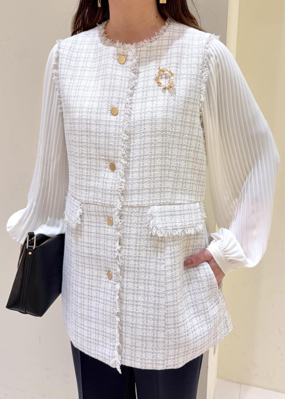 ブラック系のショルダーバッグ、ブルー系のその他パンツ、グレー系のベストを着用したレディースの冬コーディネートの4枚目の写真