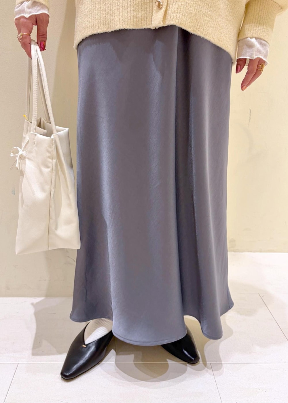 ベージュ系のカーディガン/ボレロ、ホワイト系のトートバッグ、ホワイト系のTシャツ/カットソーを着用したレディースの冬コーディネートの8枚目の写真