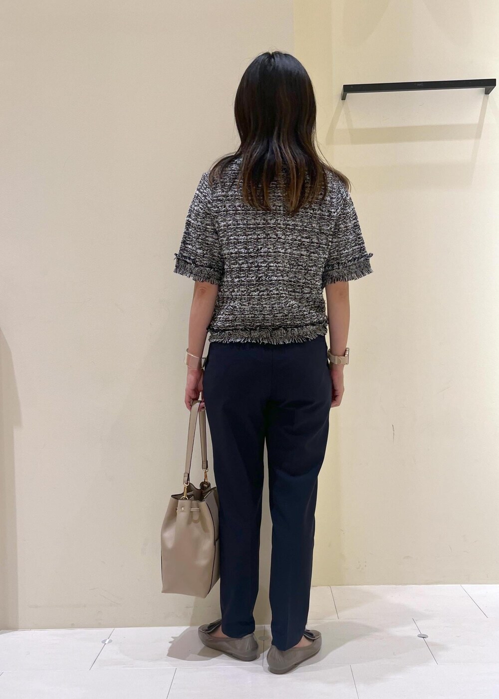 ブルー系のスラックス、ベージュ系のショルダーバッグ、ブラック系のカーディガン/ボレロを着用したレディースの夏コーディネートの4枚目の写真