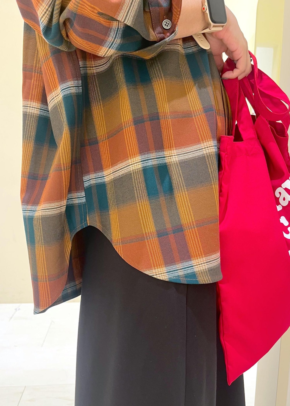 ブラック系のスカート、オレンジ系のシャツ/ブラウス、レッド系のトートバッグを着用したレディースの秋コーディネートの7枚目の写真