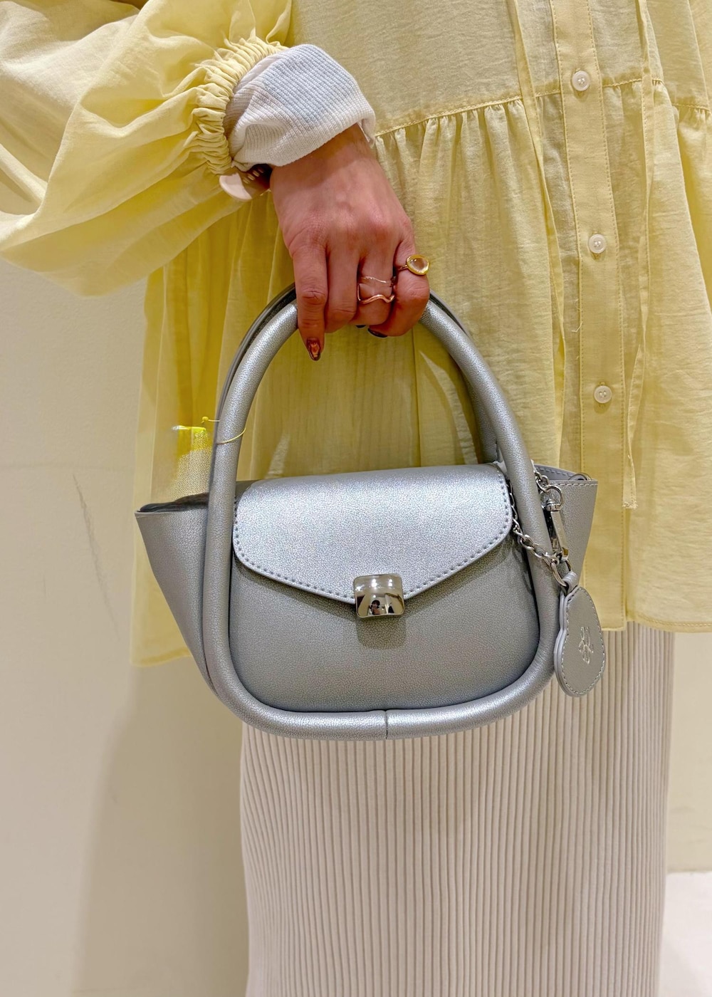 ホワイト系のTシャツ/カットソー、シルバー系のショルダーバッグ、ホワイト系のスカートを着用したレディースの春コーディネートの9枚目の写真