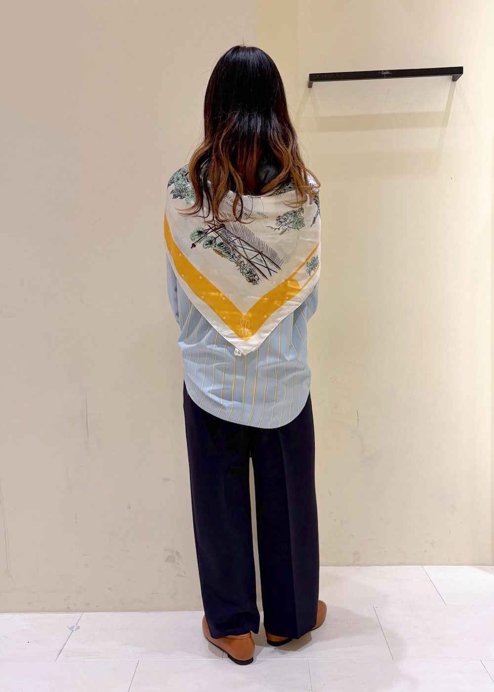 イエロー系のローファー、ホワイト系のボストンバッグ、ブルー系のその他パンツを着用したレディースの春コーディネートの3枚目の写真