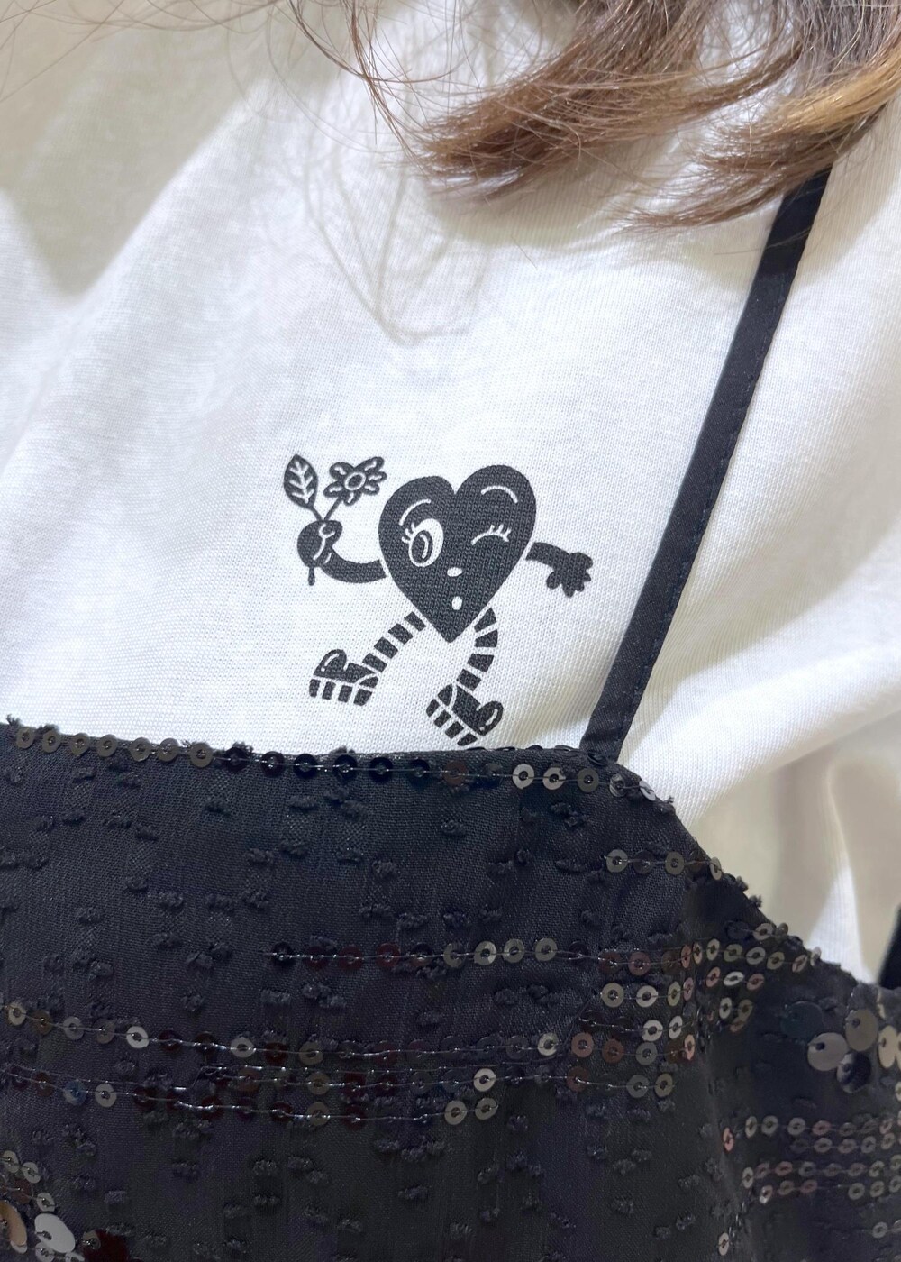 ブラック系のTシャツ/カットソー、ホワイト系のサンダル、ベージュ系のバックパック/リュックを着用したレディースの夏コーディネートの5枚目の写真