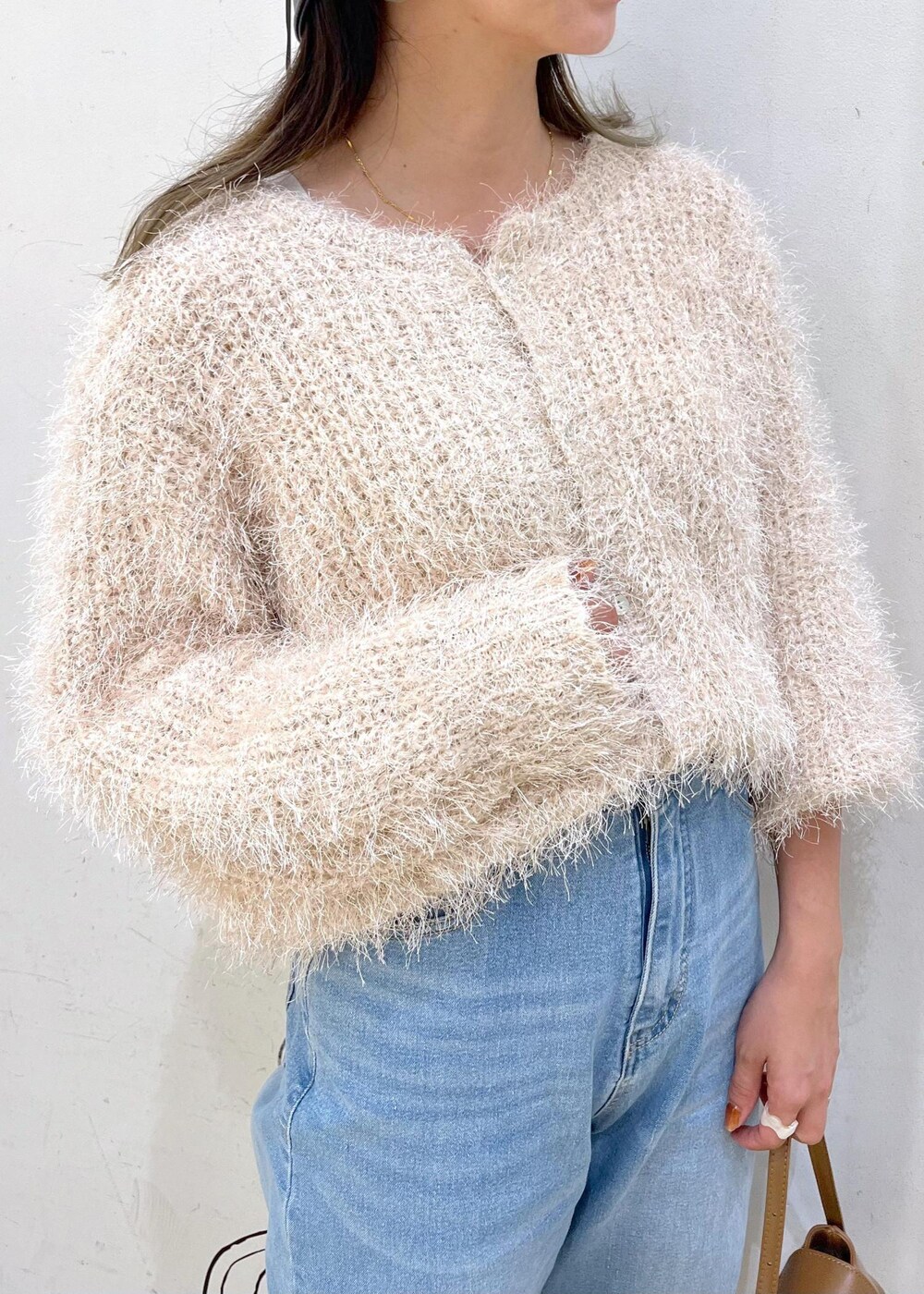 グレー系のタンクトップ、ブルー系のデニムパンツ、ベージュ系のカーディガン/ボレロを着用したレディースの秋コーディネートの7枚目の写真