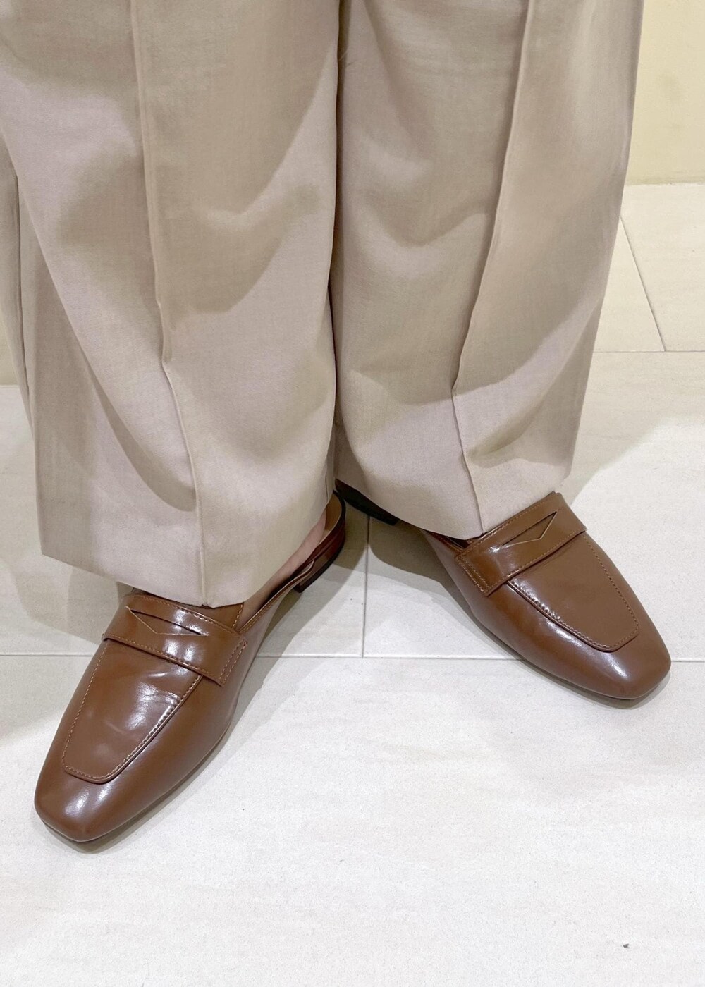 イエロー系のローファー、ベージュ系のその他パンツ、ブラウン系のショルダーバッグを着用したレディースの夏コーディネートの9枚目の写真