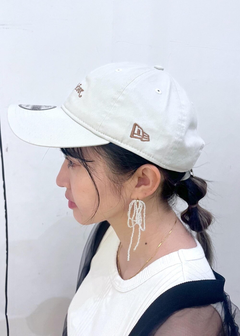 イエロー系のスカート、ブラック系のカーディガン/ボレロ、ホワイト系のスニーカーを着用したレディースの秋コーディネートの5枚目の写真