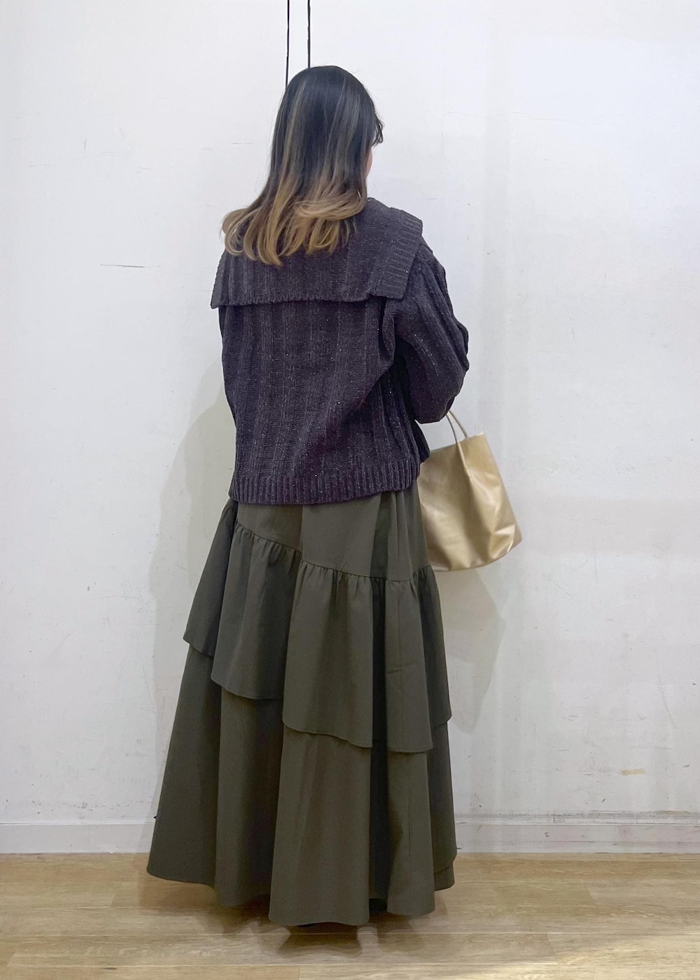 ホワイト系のニット/セーター、ブラック系のバレエシューズ、グリーン系のスカートを着用したレディースの冬コーディネートの4枚目の写真