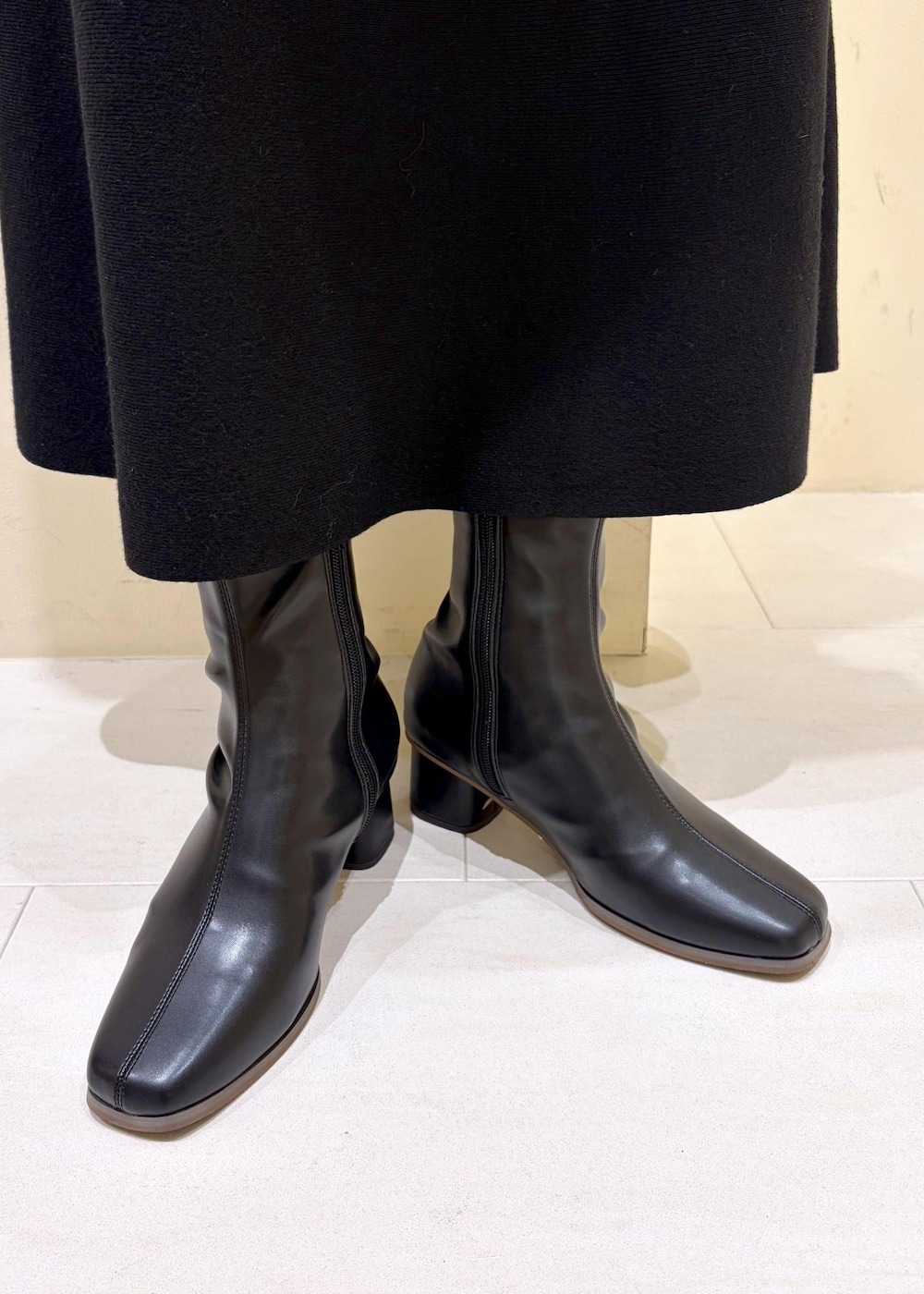 ブラック系のブーツ、ベージュ系のショルダーバッグ、ブラック系のワンピースを着用したレディースの冬コーディネートの10枚目の写真