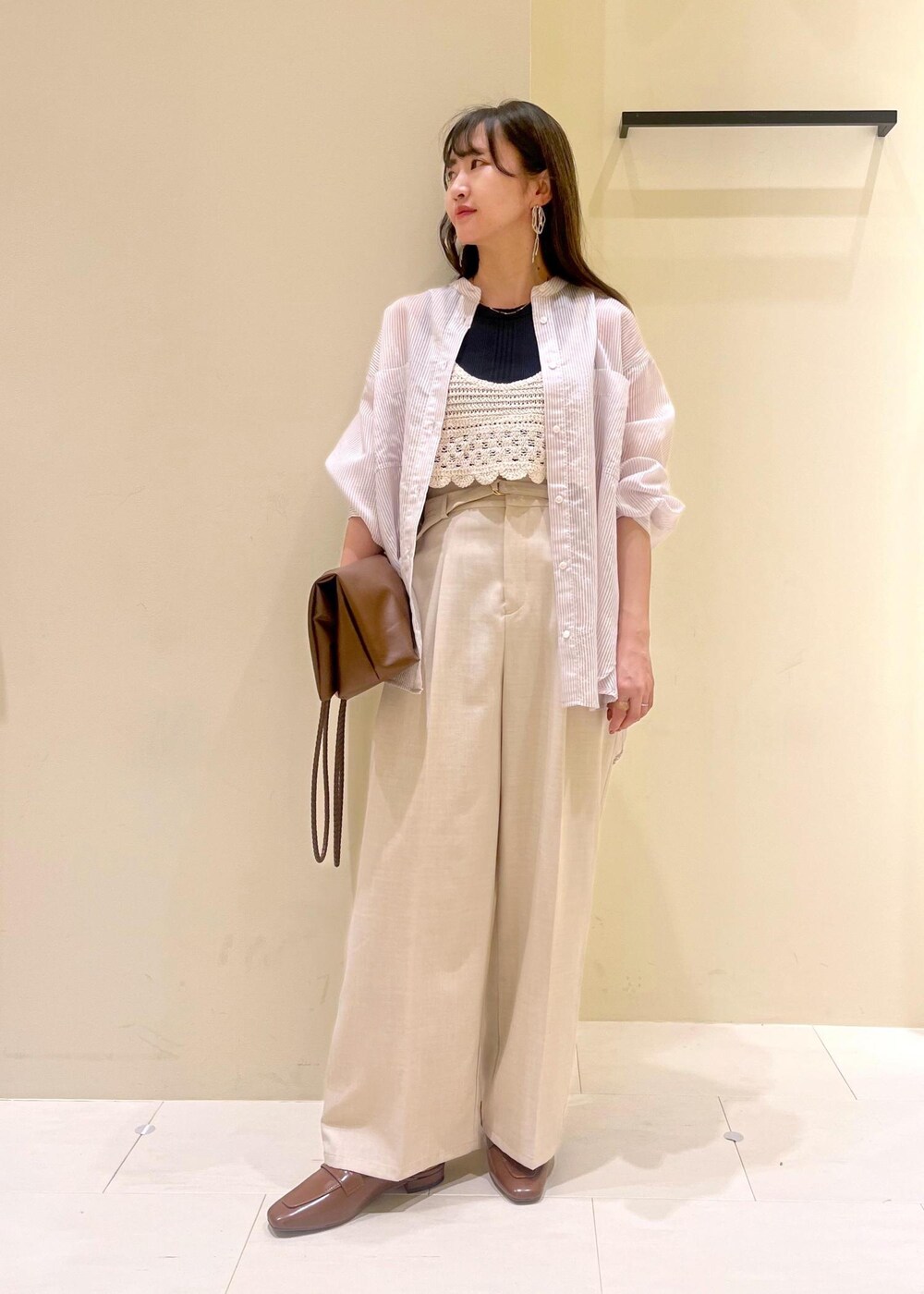 ブラック系のタンクトップ、ブラウン系のトートバッグ、イエロー系のローファーを着用したレディースの春コーディネートの2枚目の写真