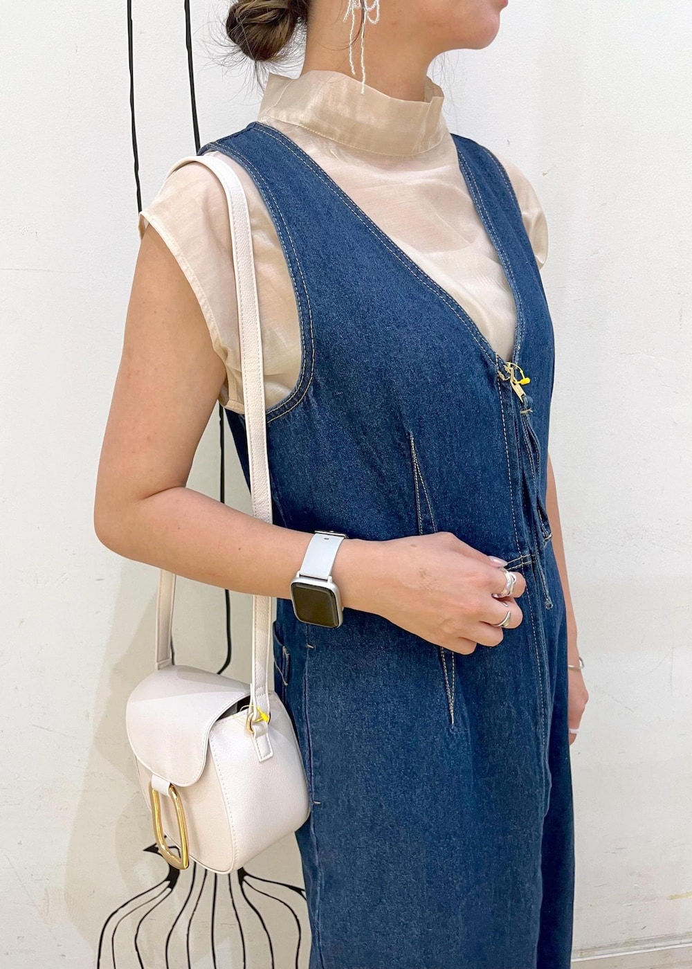 グレー系のタンクトップ、ブラック系のパンプス、ホワイト系のショルダーバッグを着用したレディースの夏コーディネートの5枚目の写真