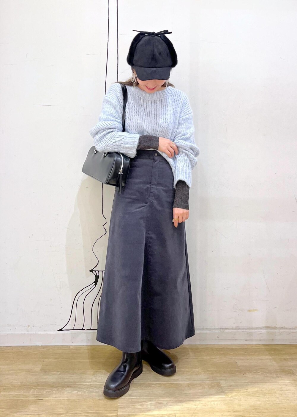 ブラック系のニット/セーター、ブラック系のブーツ、ブラック系のボストンバッグを着用したレディースの冬コーディネートの3枚目の写真