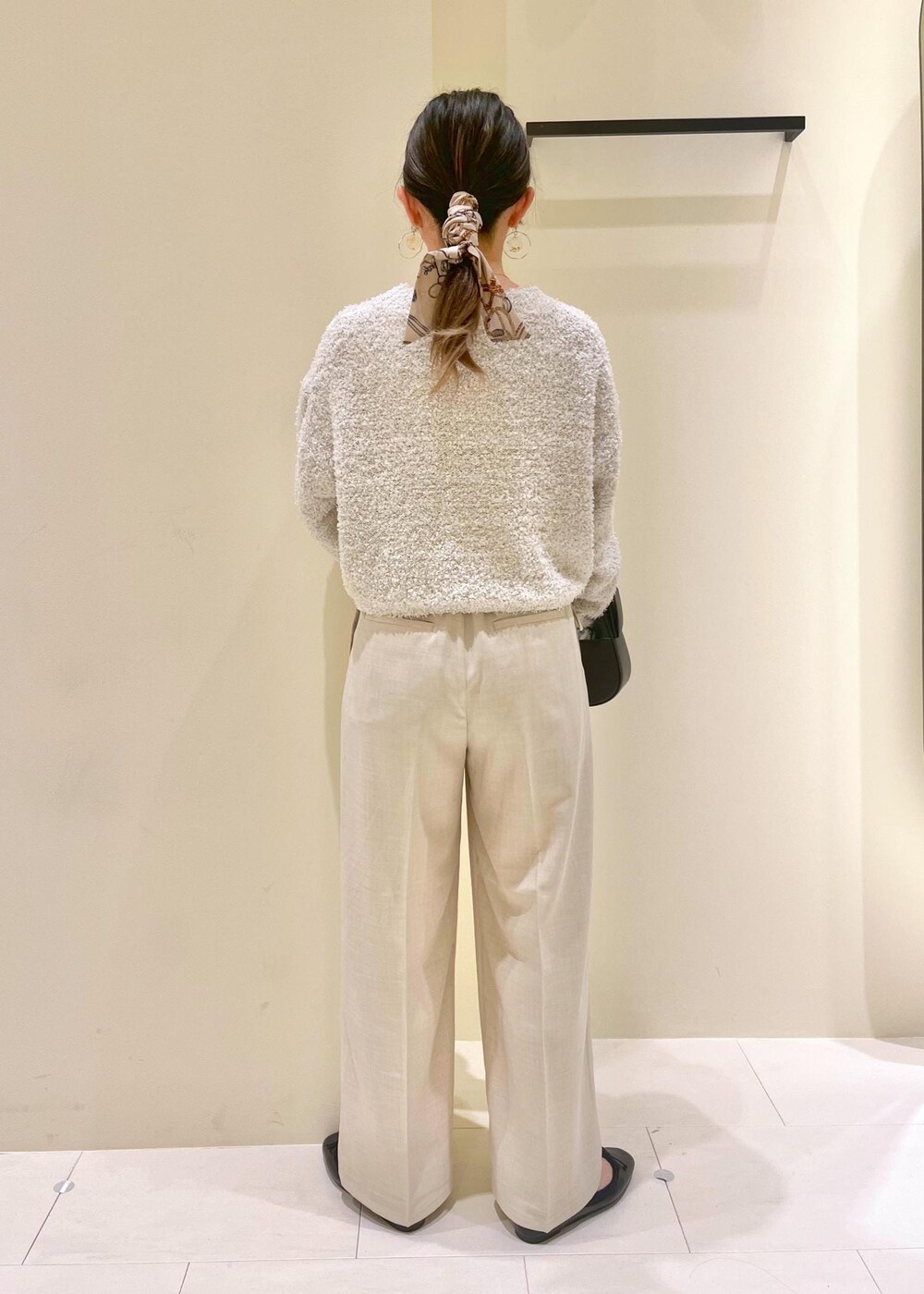 ブラック系のハンドバッグ、グレー系のニット/セーター、ブラック系のバレエシューズを着用したレディースの春コーディネートの5枚目の写真