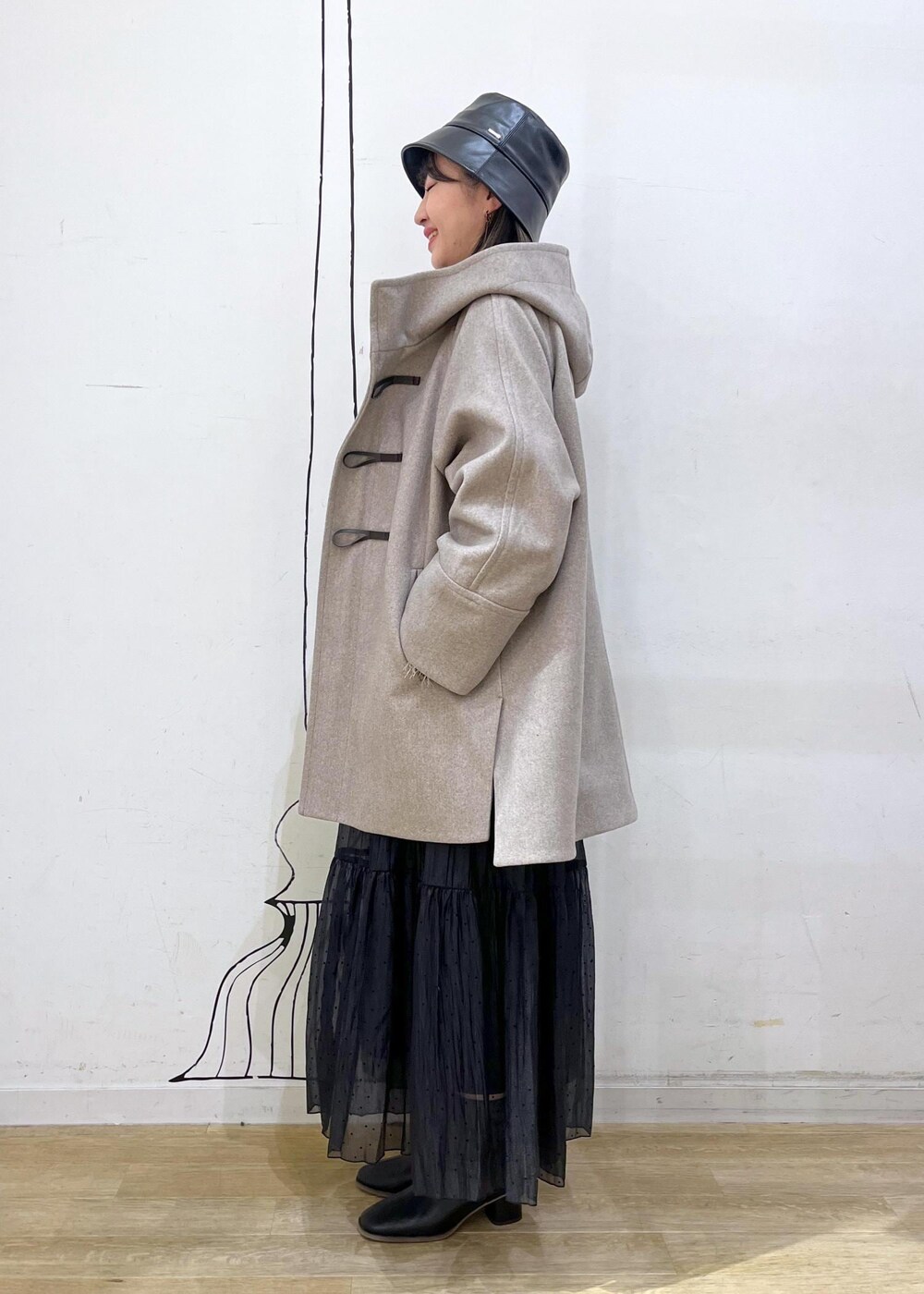 グレー系のTシャツ/カットソー、ベージュ系のカーディガン/ボレロ、ブラック系のブーツを着用したレディースの秋コーディネートの3枚目の写真