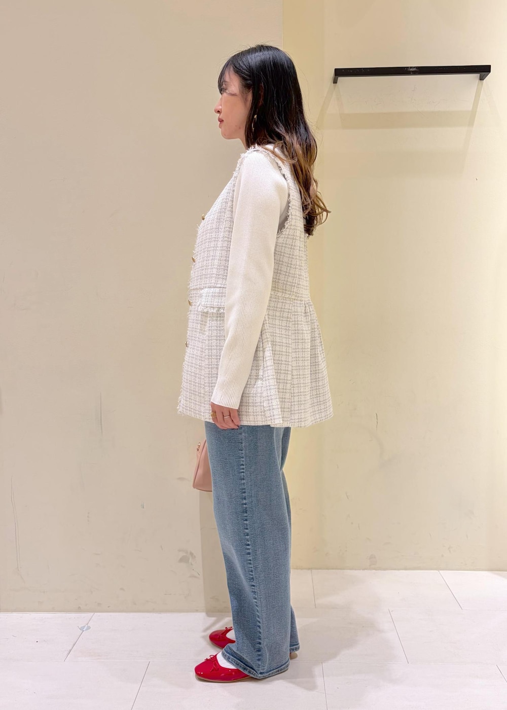 レッド系のバレエシューズ、ピンク系のボストンバッグ、ホワイト系のニット/セーターを着用したレディースの春コーディネートの2枚目の写真