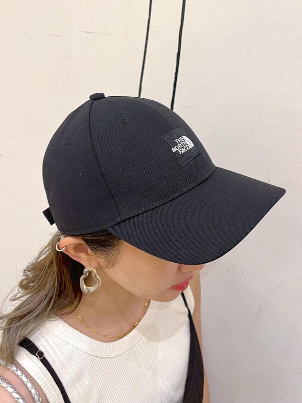 シルバー系のトートバッグ、ベージュ系のタンクトップ、ブラック系のワンピースを着用したレディースの夏コーディネートの7枚目の写真