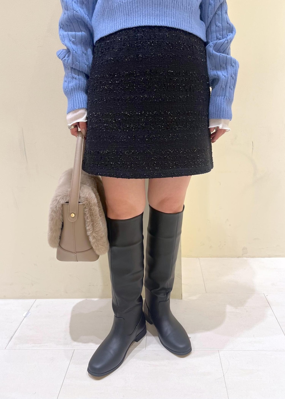 ブルー系のスカート、ホワイト系のTシャツ/カットソー、ブルー系のニット/セーターを着用したレディースの冬コーディネートの6枚目の写真